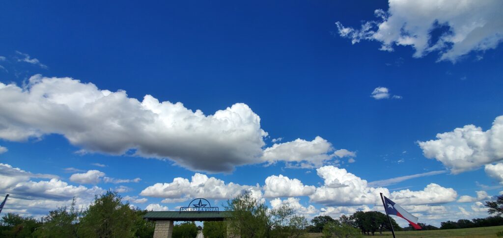 A blue sky with some clouds in the background