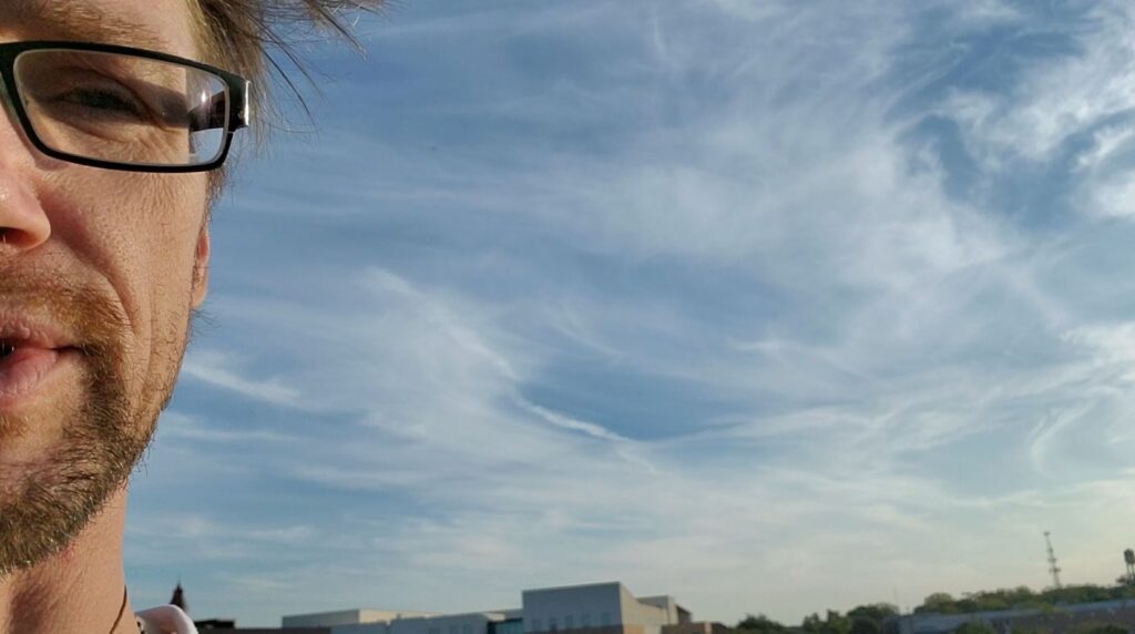 A blue sky with some clouds in the background